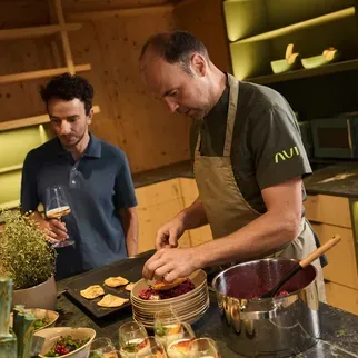 Nella cucina ben attrezzata dell’hotel AUI, due uomini sono impegnati nella preparazione dei cibi.