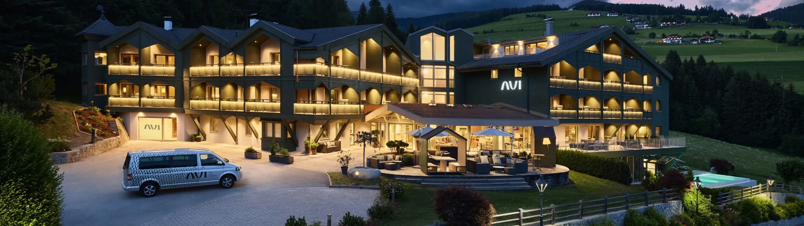 Das AUI Hotel in Meransen mit seiner modernen Architektur vor der beeindruckenden Kulisse majestätischer Berge.