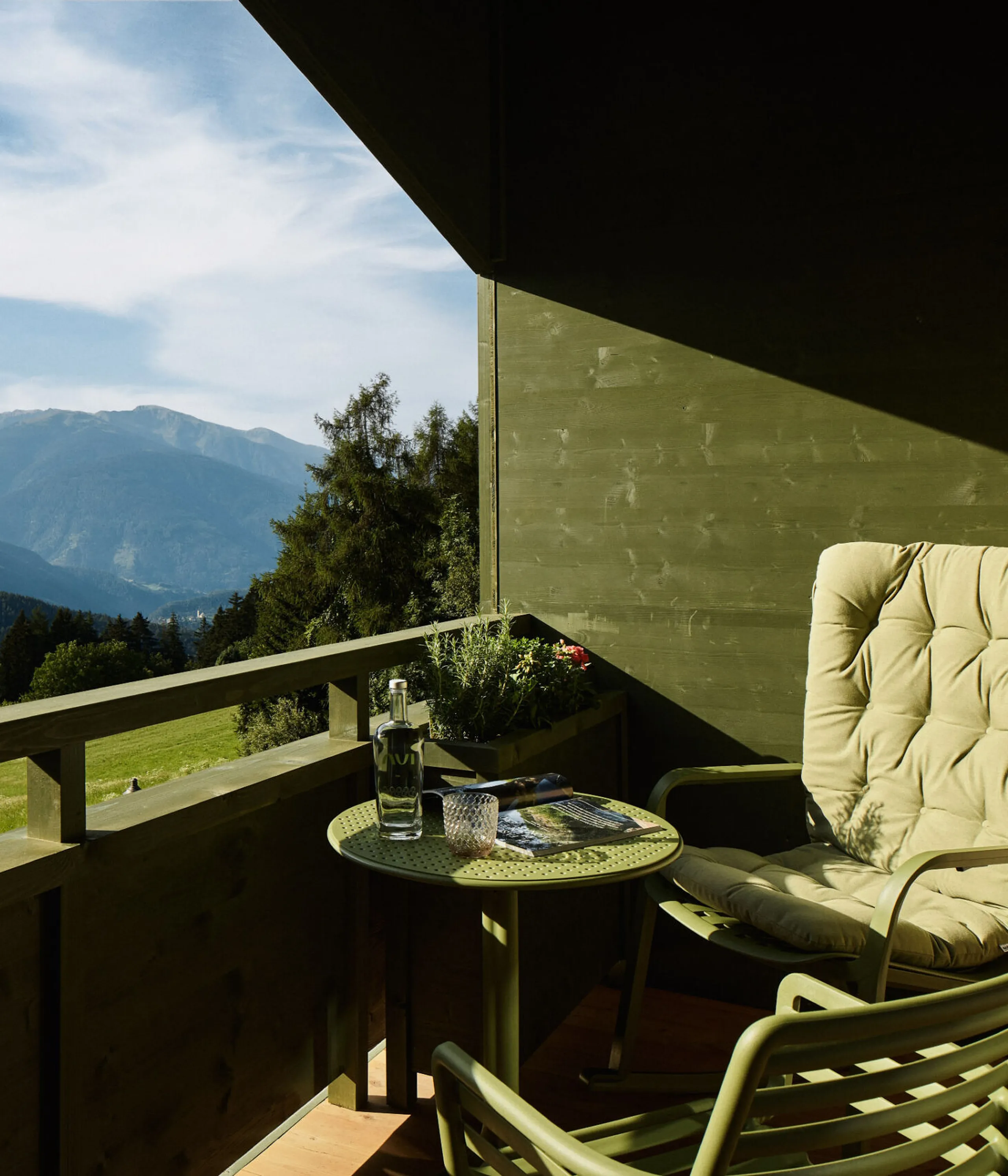Balcone dell’AUI con poltrona e tavolino, circondato da un suggestivo panorama montano.