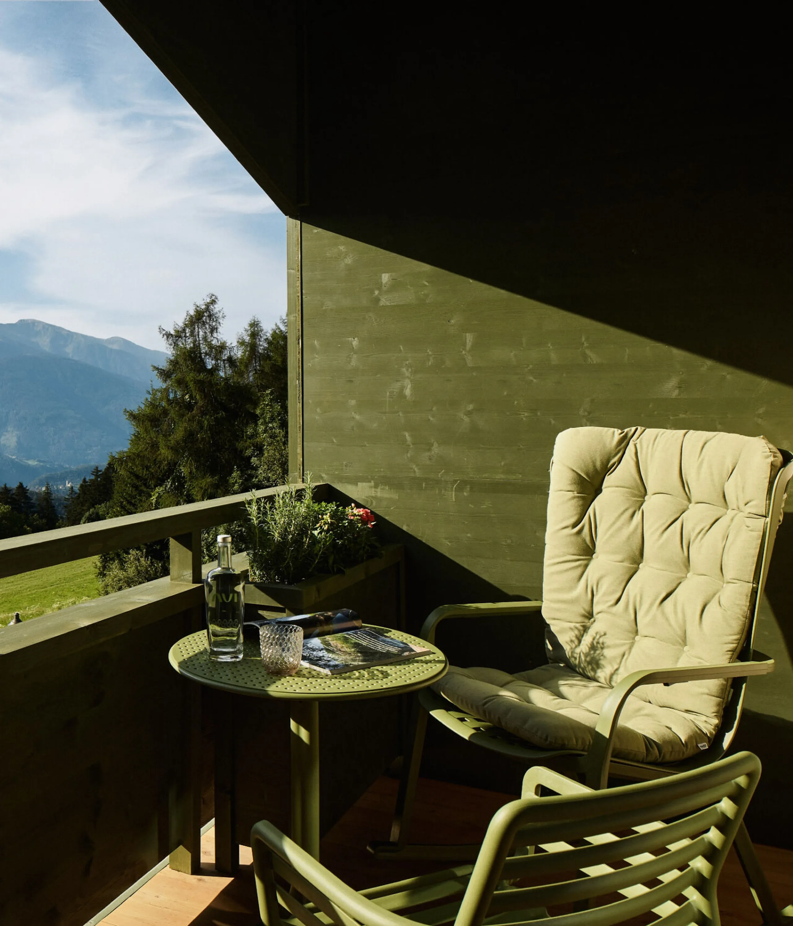 AUI balcony featuring a chair and a small table, surrounded by a scenic view.