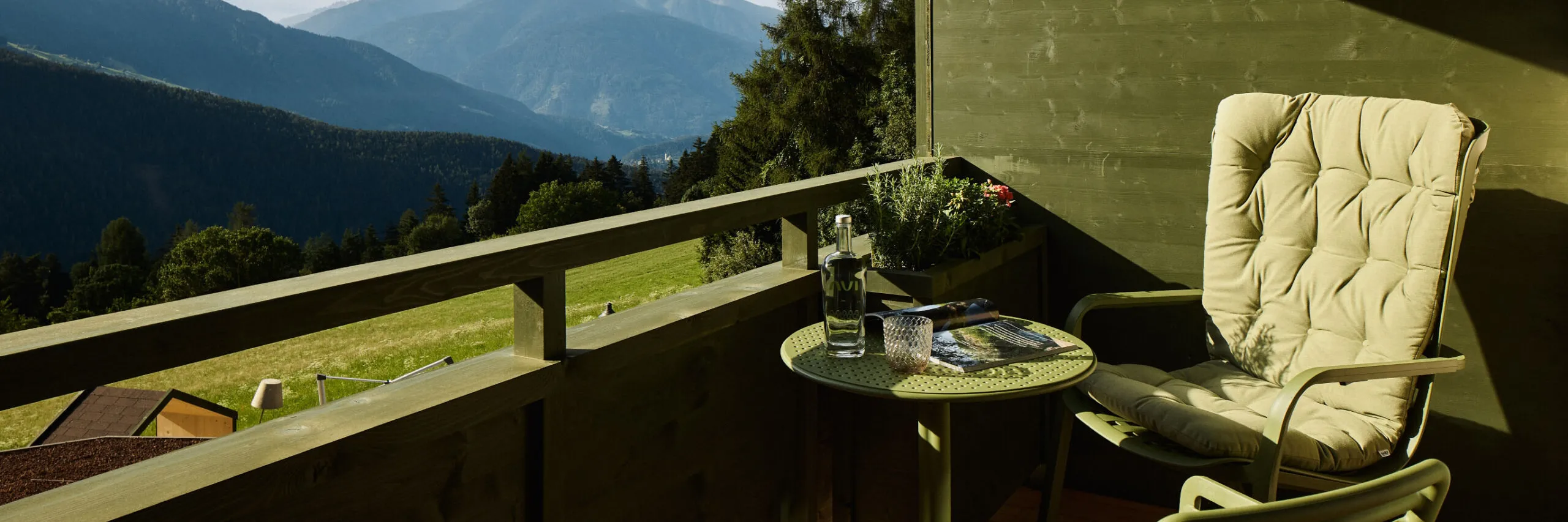 AUI balcony featuring a chair and a small table, surrounded by a scenic view.