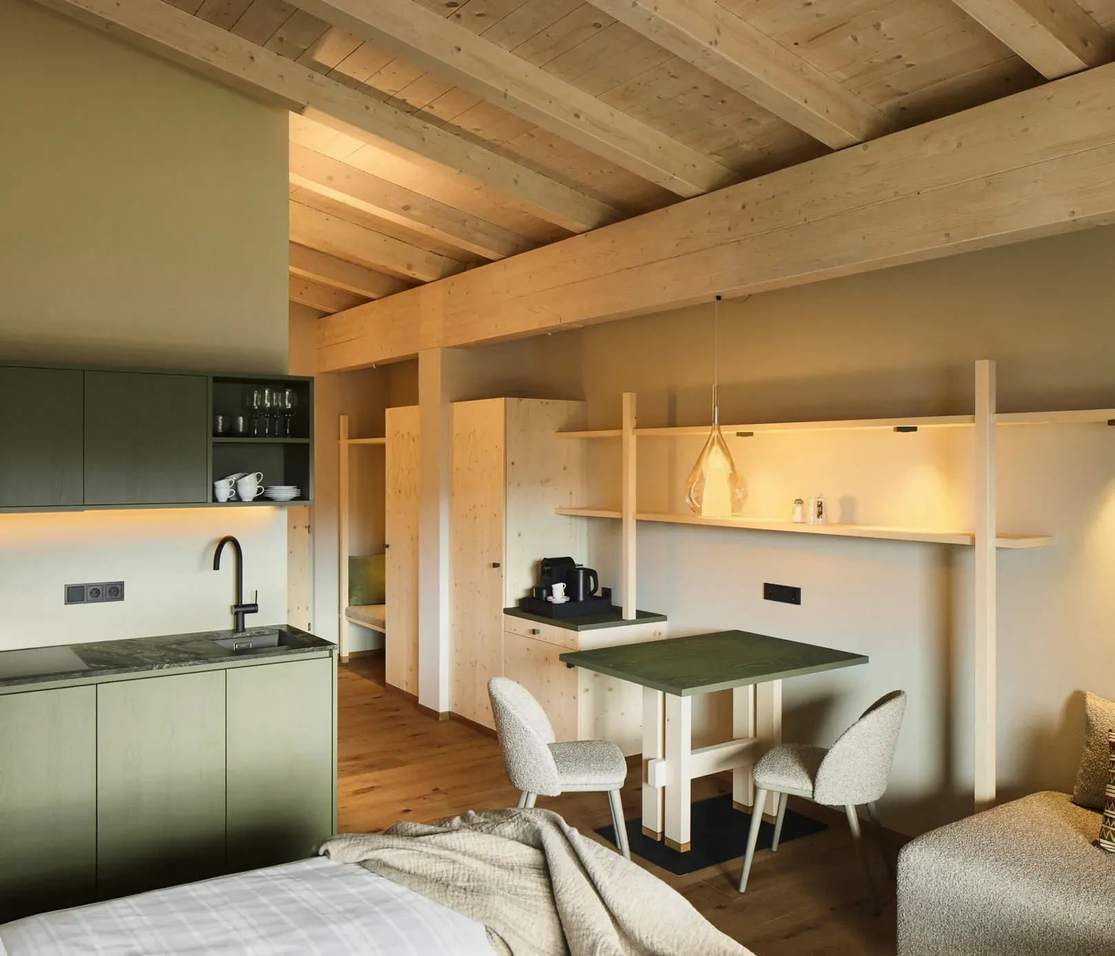 Kompakte Küche und Wohnbereich in einem AUI Apartment mit modernen Geräten und gemütlicher Einrichtung.