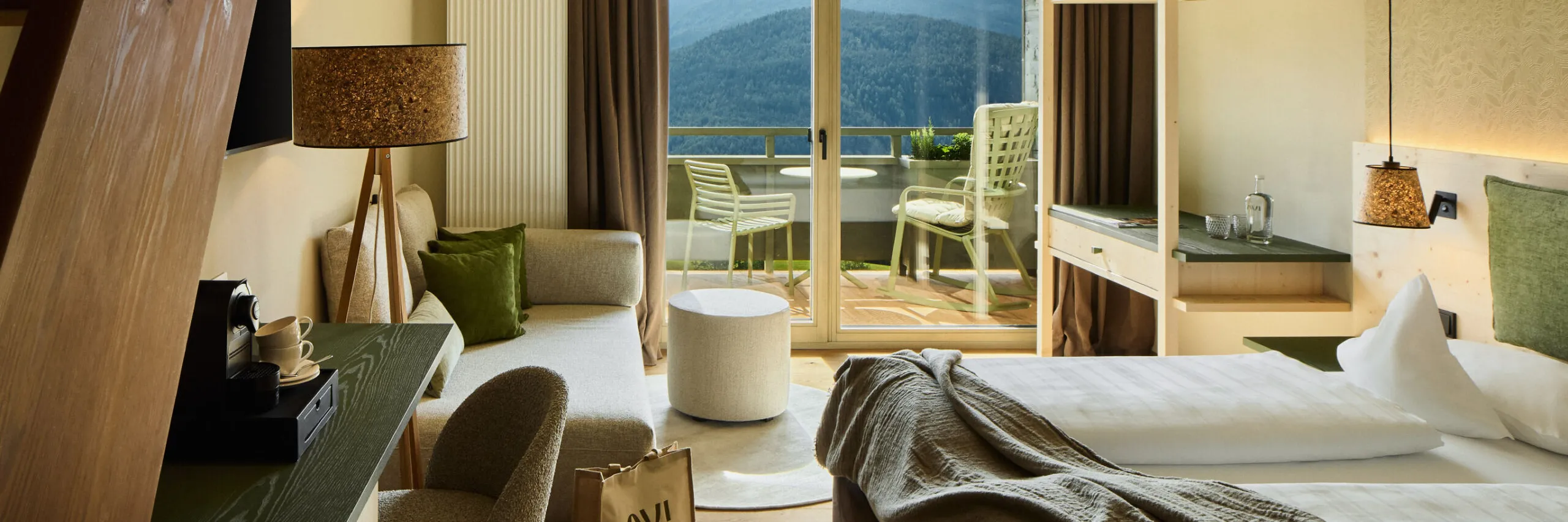 Stilvoll eingerichtete AUI Suite mit Bett und großem Fenster mit einem malerischen Blick auf die Berge.