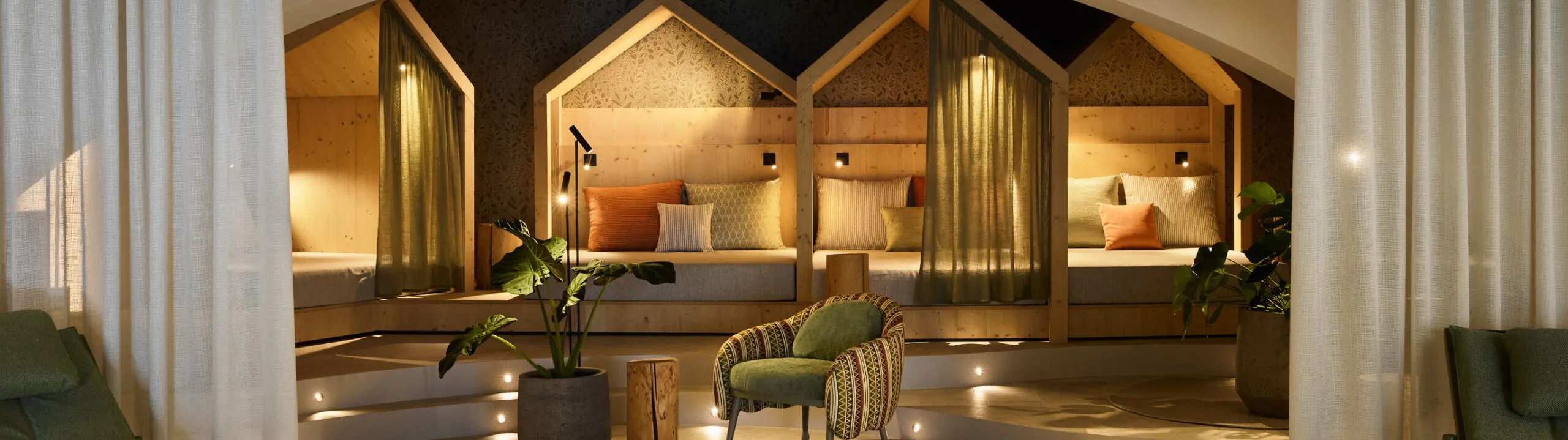 Wellnessraum im AUI Hotel mit einem großen Bett, bequemen Sesseln und einer ruhigen Atmosphäre zum Entspannen und Wohlfühlen.